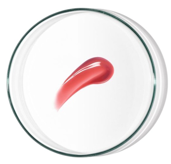 A smooth, glossy pink cream swatch on a clear circular dish, showcasing the Babe Lip & Cheek SPF50 product's vibrant color and creamy texture.