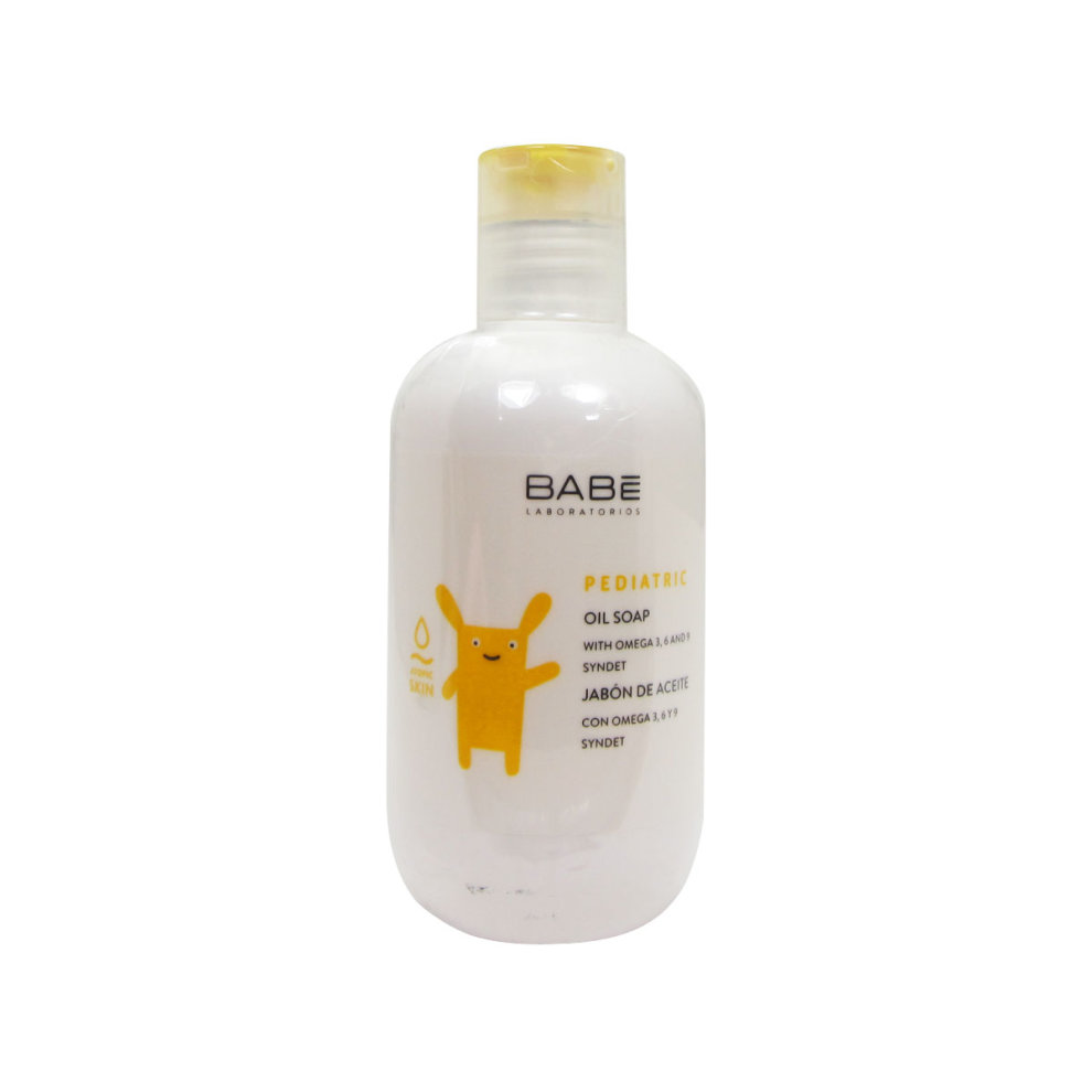 White plastic bottle of Babe Babé Pediatric Oil Soap for atopic skin, featuring a cheerful yellow cartoon character and a flip-top lid, labeled with key ingredients and volume.