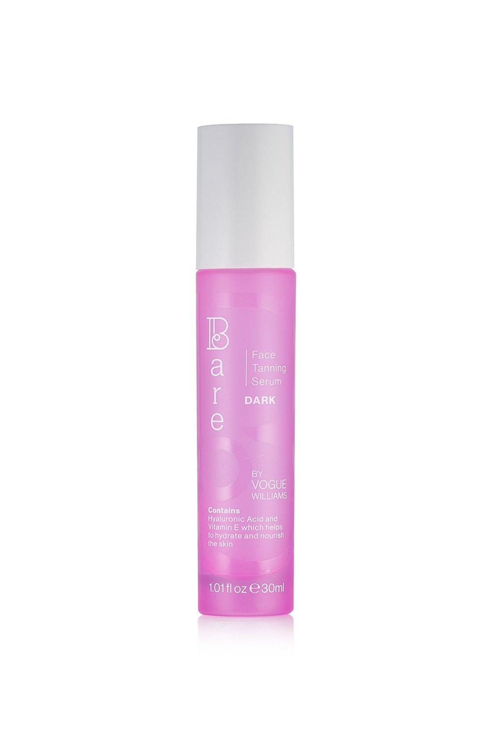 Pink cylindrical bottle with a white cap, labeled "Bare by Vogue" and "Face Tanning Serum Dark," containing 30ml, featuring key ingredients like Hyaluronic Acid.