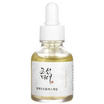 Clear glass dropper bottle containing a golden serum, labeled in white and black with Korean text, featuring a white dropper lid and a minimalist design.