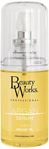 Clear plastic bottle with a pump dispenser, filled with golden argan oil serum, labeled "Beauty Works Professional Argan Serum" in black and gold text, size 90ml.