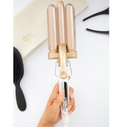 Debenhams the Waver by Beauty Works features a gold and rose gold triple barrel design, with a white handle and a sleek, modern aesthetic, ideal for creating waves in hair.