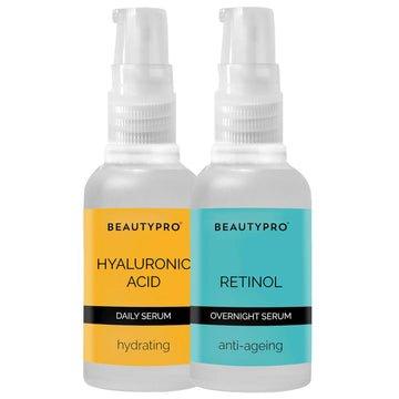 Two clear bottles of BeautyPro serums: one yellow labeled "Hyaluronic Acid" for hydration, and one blue labeled "Retinol" for anti-aging, both with pump dispensers.