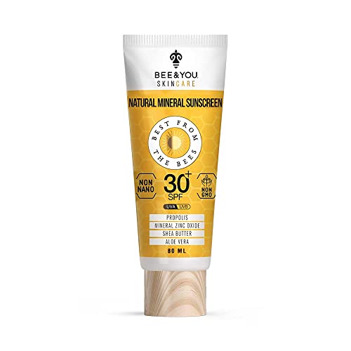 Mineral sunscreen cream in a white tube with a yellow label, featuring SPF 50+, made with natural ingredients like propolis and shea butter, with a wooden cap.