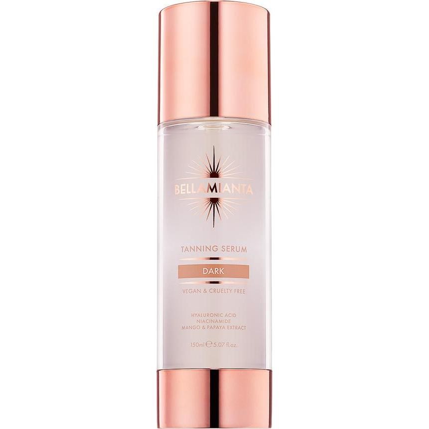 Clear bottle with a rose gold cap, labeled "Bellamianta Tanning Serum Dark," featuring 150ml capacity, vegan and cruelty-free claims, and key ingredients like hyaluronic acid.