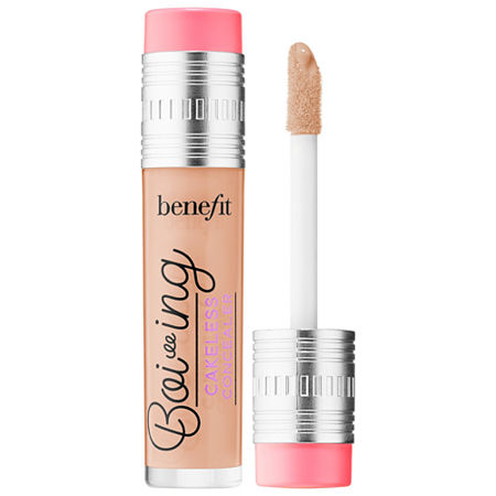 Boi-ing Cakeless Concealer No. 2.5 by Benefit features a sleek, clear tube with a silver cap and a pink accent, containing a creamy beige concealer and a doe-foot applicator.