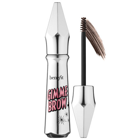 Silver cylindrical tube with a pointed cap, featuring pink and black text reading "Gimme Brow," alongside a small brush applicator with brown tinted gel for volumizing eyebrows.