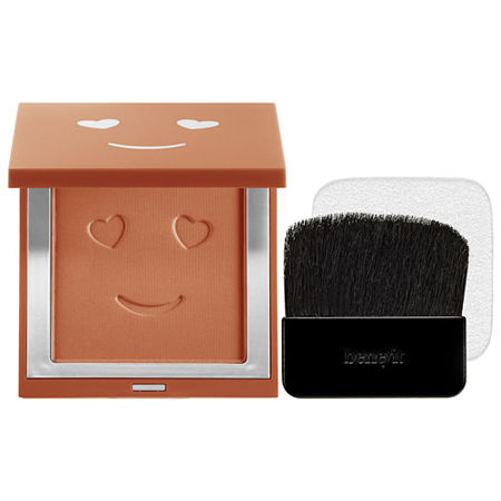Compact foundation in a square, orange case featuring a smiling face design, with a soft brush included, offering a velvet matte finish in shade 11 Dark Neutral.