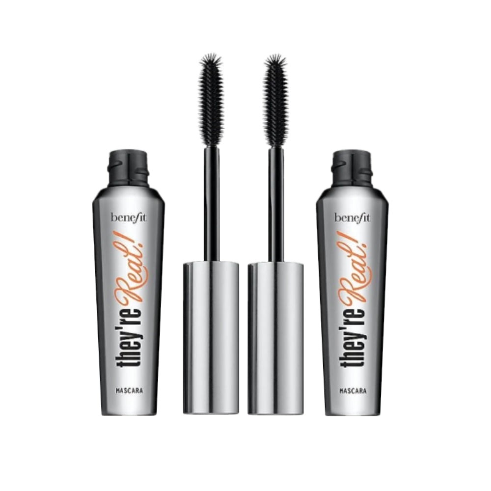 Two tubes of Benefit They're Real! Jet Black mascara, featuring a sleek silver design with bold orange text, accompanied by two black, bristle mascara wands.