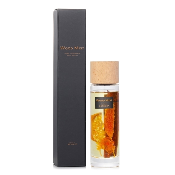 Clear glass reed diffuser with orange and cinnamon accents, topped with a natural wood cap, packaged in a sleek black box labeled "Wood Mist" by Botanica.