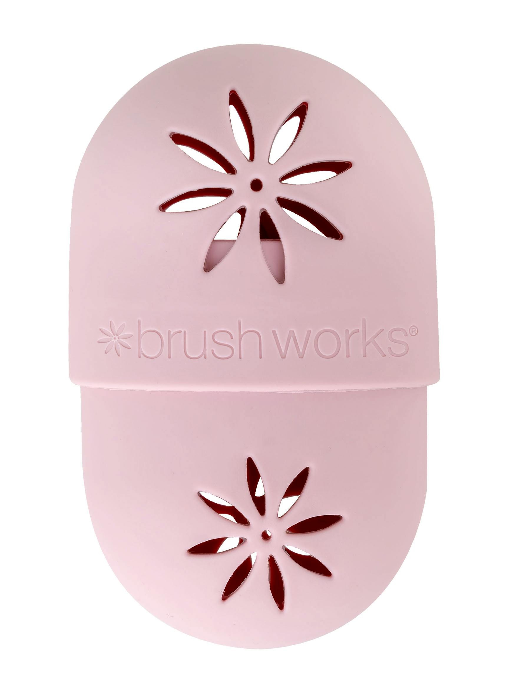 Pink silicone makeup sponge shield featuring a floral cut-out design and the "brush works" logo, designed to protect makeup sponges.