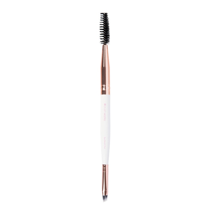 White and gold dual-ended brow brush featuring a spoolie on one end and an angled brush on the other, with a sleek, metallic rose gold handle.