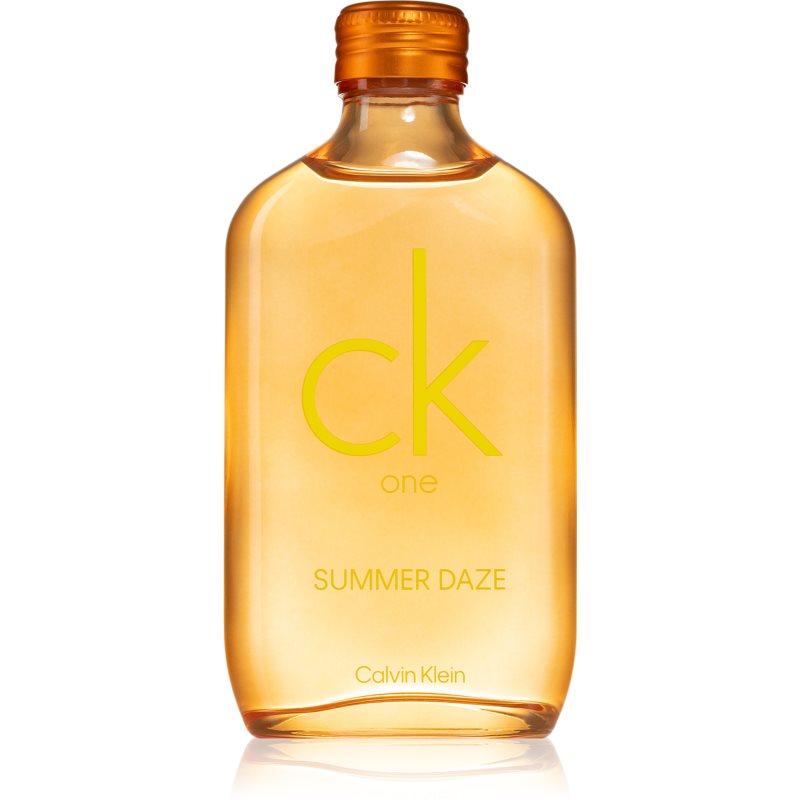 Clear bottle with a rounded shape, filled with amber-colored liquid, featuring a bright yellow "ck" logo and "SUMMER DAZE" text, topped with an orange cap.