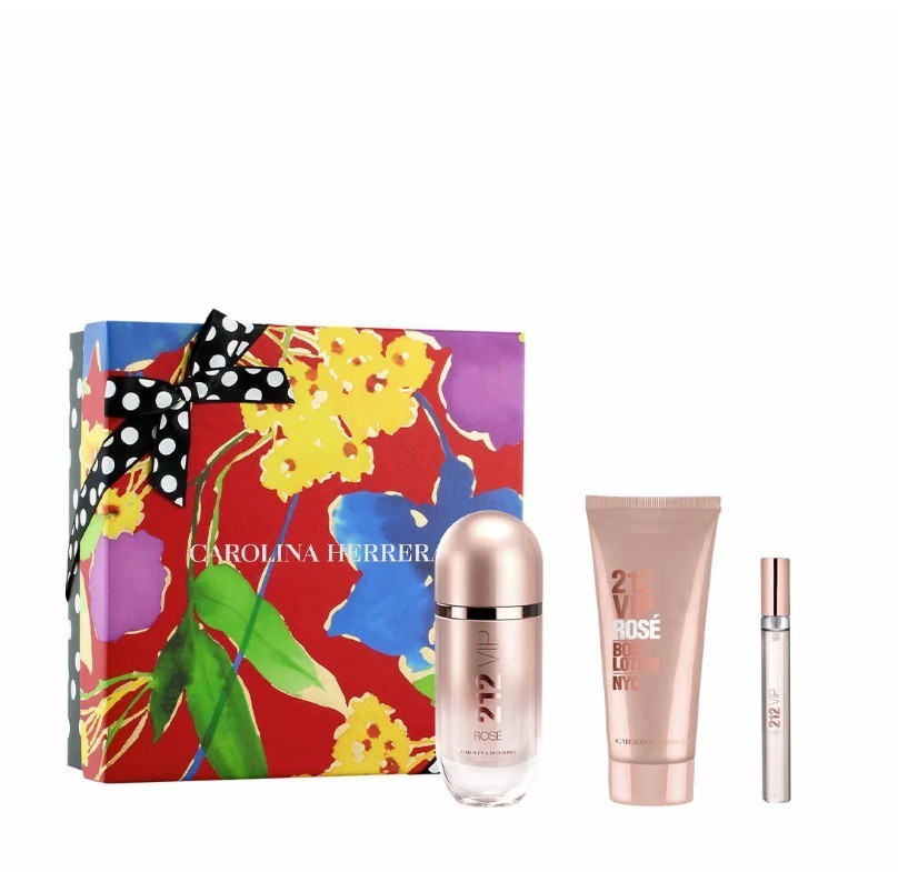 Carolina Herrera 212 VIP Rose gift set featuring a rose gold bottle, a pink lotion tube, and a travel-size spray, all presented in a colorful floral box with a black polka dot ribbon.