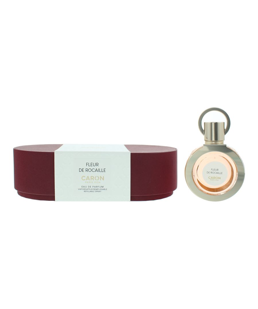 Elegant round bottle of Fleur De Rocaille Eau De Parfum by Caron, featuring a gold cap and a soft pink liquid, alongside a maroon and white box packaging.