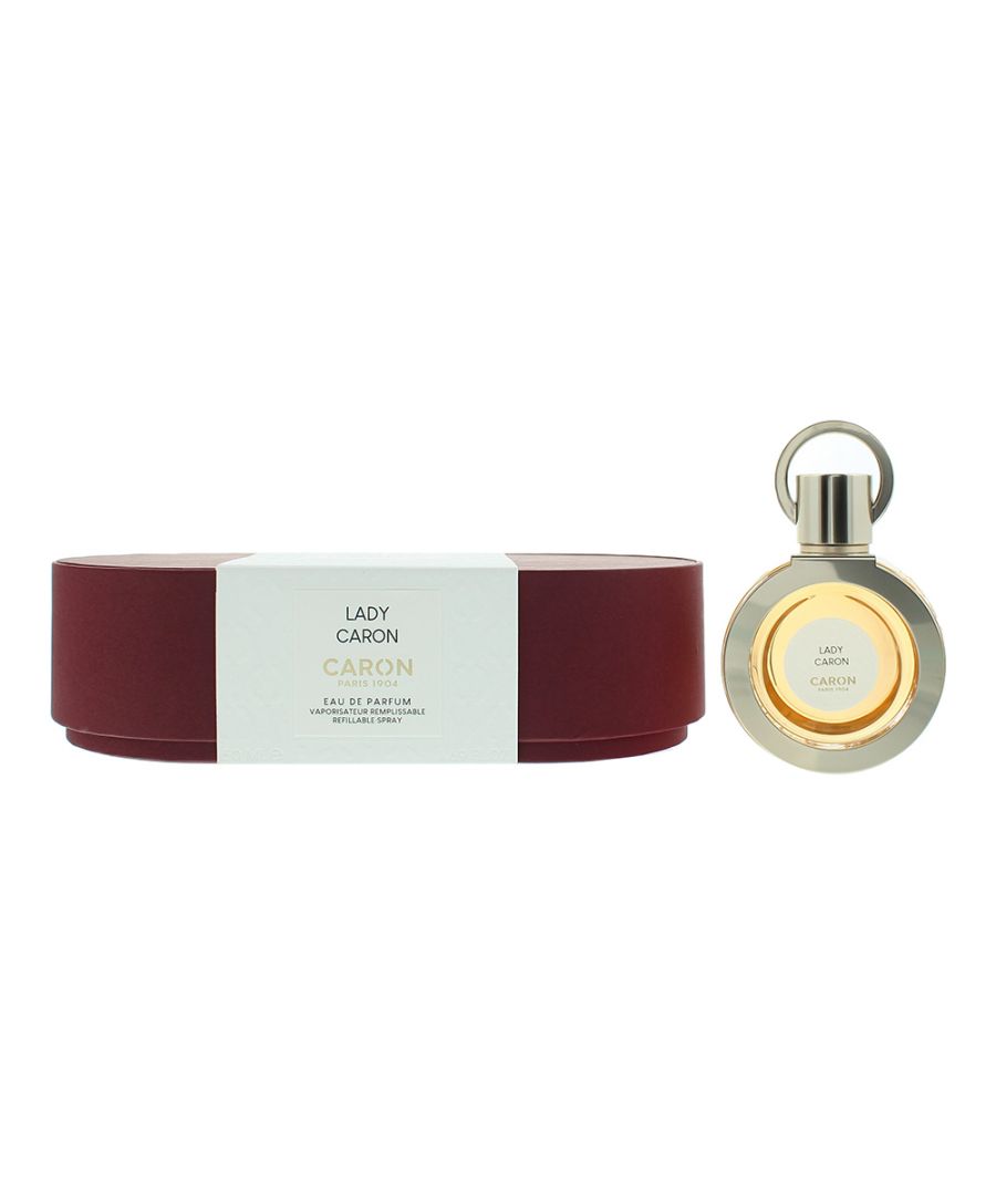 Elegant round bottle of Caron Lady Caron Eau De Parfum, 50ml, with a gold cap, beside a deep burgundy circular box featuring embossed white detailing.