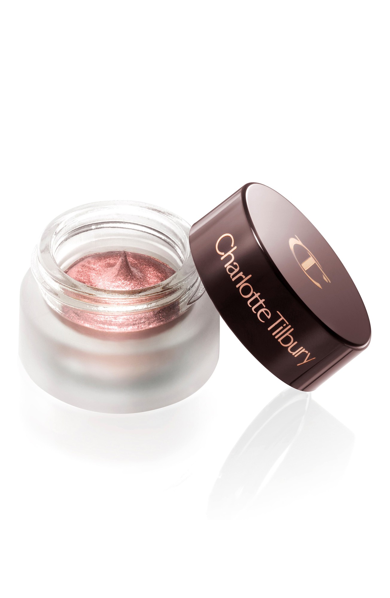 A clear glass jar with a rose gold lid, containing shimmering pink cream eyeshadow labeled "Charlotte Tilbury Eyes to Mesmerise - #Pillow Talk."