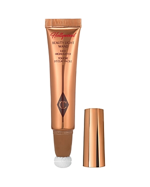 Rose gold tube with a twist cap, featuring a white sponge applicator tip, labeled "Hollywood Beauty Light Wand" in elegant script, designed for highlighting.