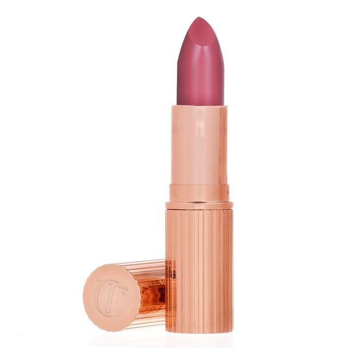 Satin shine lipstick in a coral pink shade, housed in a rose gold, ribbed tube with a rounded bullet tip, featuring the embossed logo on the cap.