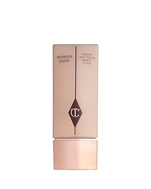 Charlotte Tilbury Wonderglow Instant Beauty Flash primer in a sleek, light beige bottle with a gold base and a diamond logo, designed for a soft focus effect on the skin.
