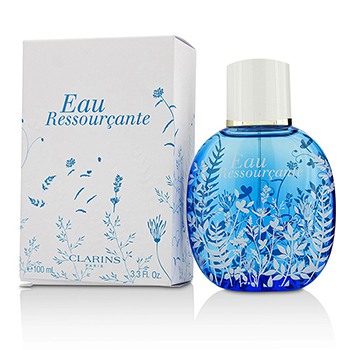 Clear blue glass bottle with a white cap, featuring a floral design, alongside a white box with blue illustrations and the text "Eau Ressourçante" in elegant font.