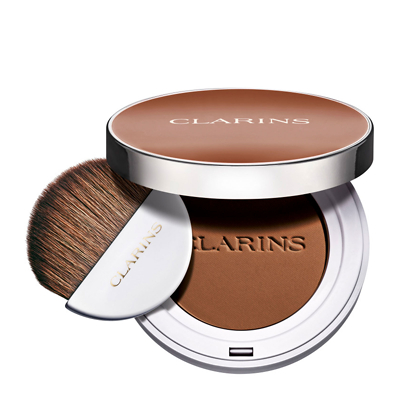 Round compact featuring a rich brown blush with "CLARINS" embossed, accompanied by a soft, rounded brush for application.