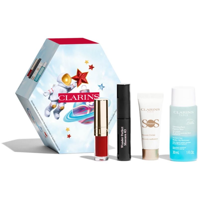Hexagonal gift box featuring a space-themed design, containing a red Lip Comfort Oil, black Wonder Perfect Mascara, white SOS Primer, and a blue Clarins product.