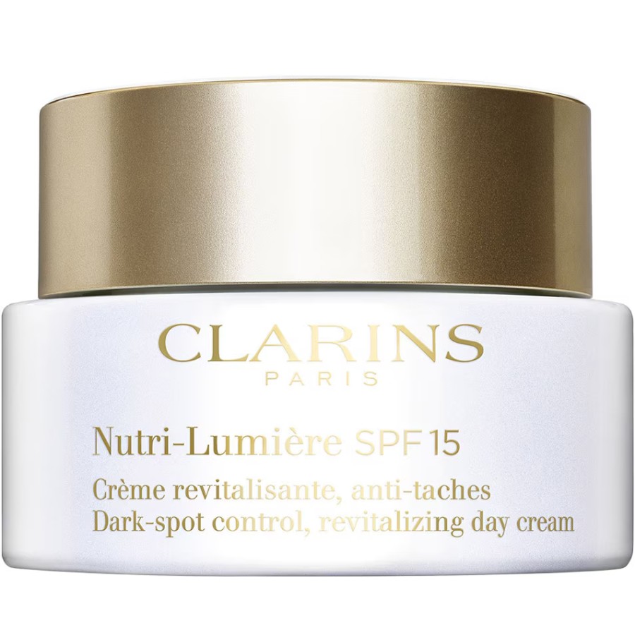White jar with a gold lid, labeled "Clarins Nutri-Lumière SPF 15," featuring revitalizing and dark-spot control properties, 50ml size.
