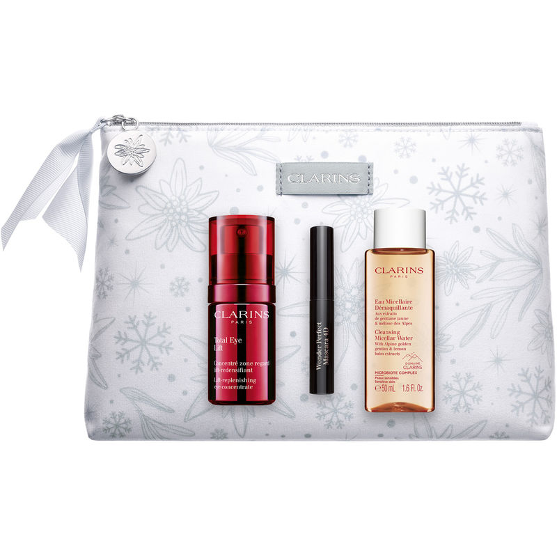 Three Clarins products in a white cosmetic bag with a floral design: Total Eye Lift (15ml, red bottle), Wonder Perfect Mascara (black tube), and Cleansing Micellar Water (50ml, peach bottle).