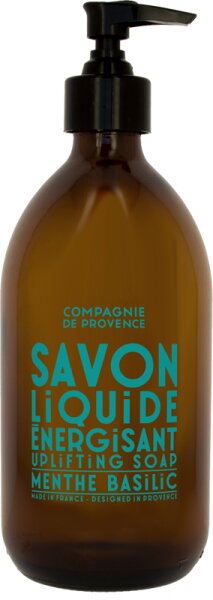 Amber glass bottle with a black pump top, featuring bright turquoise text that reads "Savon Liquide Energisant Uplifting Soap Menthe Basilic" by Compagnie de Provence.