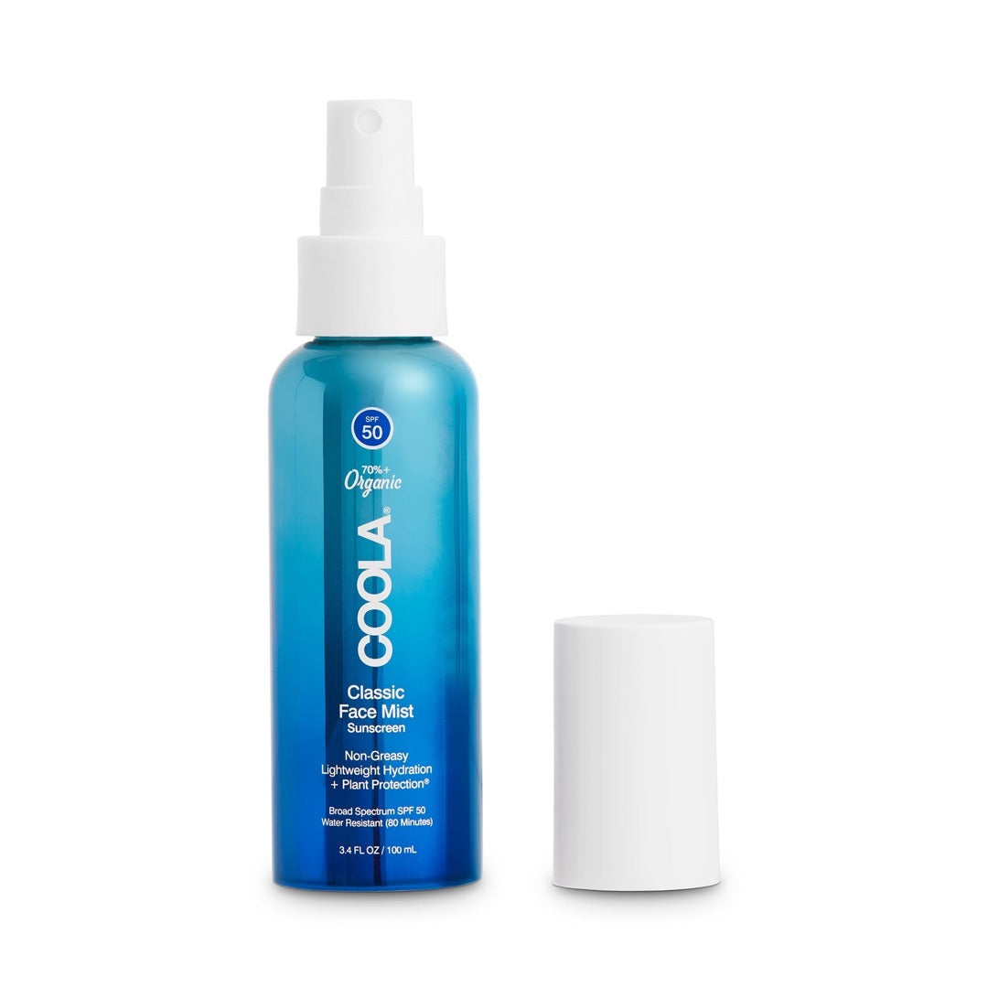 Coola Classic Face Mist SPF 50 in a blue spray bottle with a white cap, featuring organic sun protection and a lightweight, non-greasy formula for facial use.