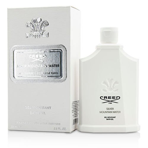 White bottle of Creed Silver Mountain Water bath gel with a silver label, accompanied by a matching white box, both featuring elegant branding and a sleek design.