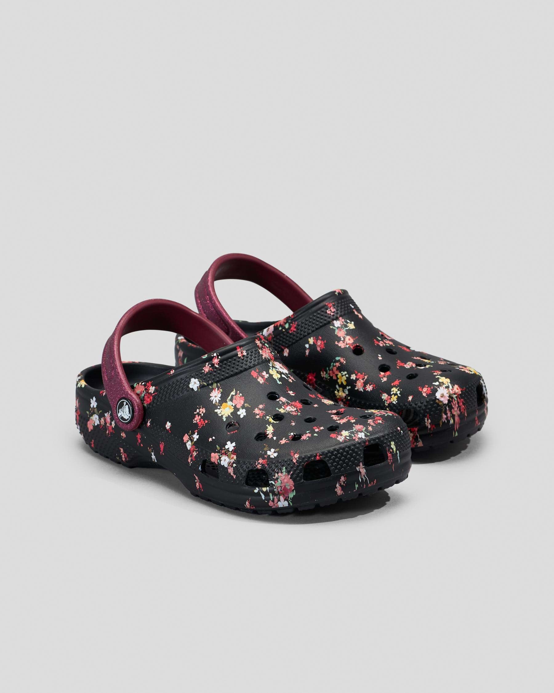 Black thermoplastic loafers with a colorful floral graphic design, featuring a maroon strap and ventilation holes for breathability.