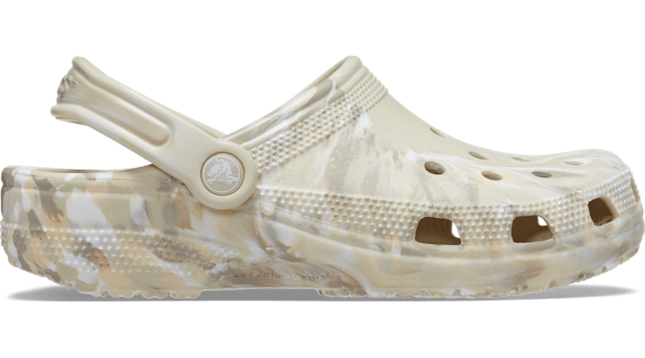 White Crocs Classic clogs featuring a camouflage pattern, made from lightweight Croslite material, with ventilation holes and a back strap for a secure fit.