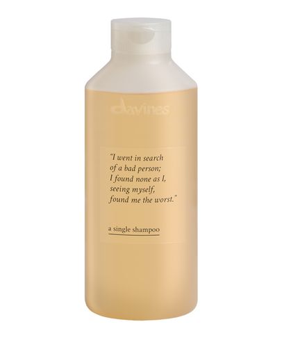 Light amber-colored shampoo bottle with a white cap, featuring a quote and product name "a single shampoo" on the label.