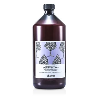 Dark purple bottle of Davines Naturaltech Calming Shampoo, featuring a floral design on a white label, with a black cap and 1000 ml capacity.