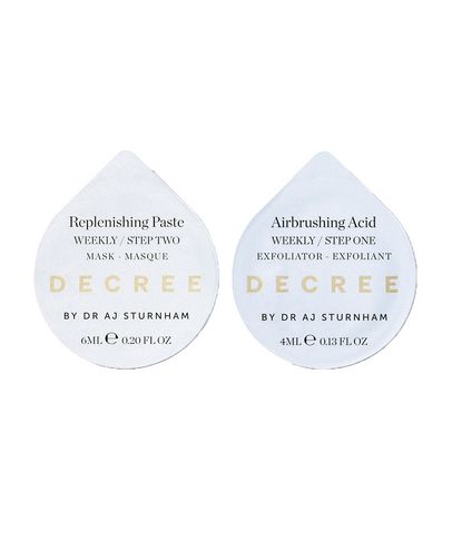 Two circular product containers labeled "Replenishing Paste" and "Airbrushing Acid," featuring a clean white background with gold text, designed for a weekly exfoliating routine.