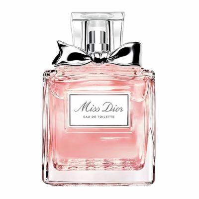 Clear glass perfume bottle with a pink liquid, featuring a silver bow on the neck and a rectangular label reading "Miss Dior Eau de Toilette."