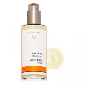 Clear glass bottle with a pump dispenser, featuring a white label with orange accents, containing a creamy lotion in a light beige color, alongside a dollop of the product.