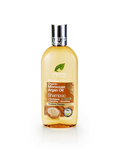 Transparent bottle containing golden liquid, labeled "Dr Organic Conditioner Moroccan Argan Oil," featuring a green leaf logo and a moisture therapy badge.