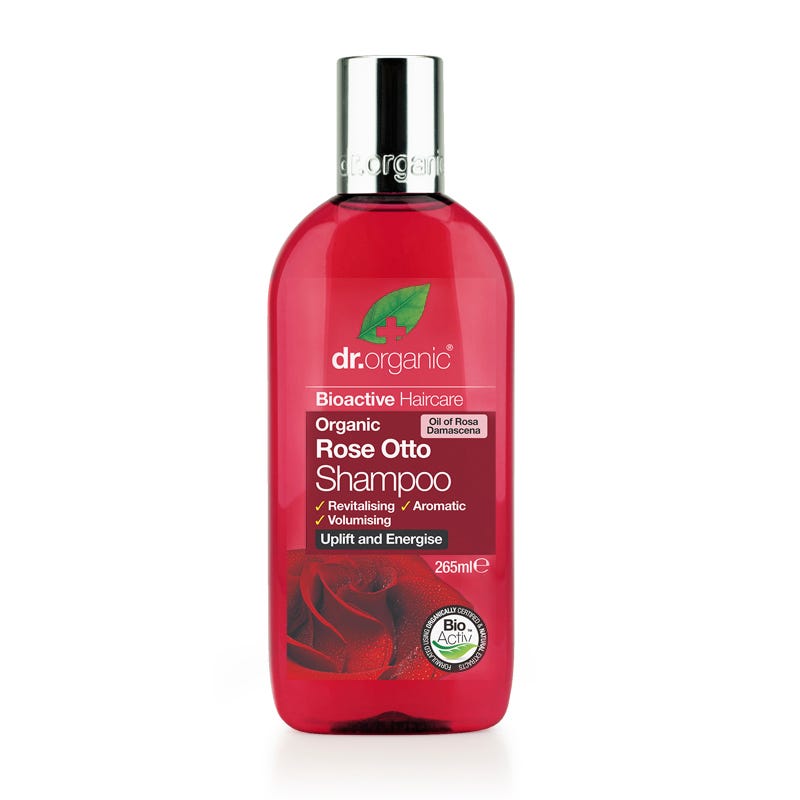 Bright pink plastic bottle of Dr Organic Rose Otto Shampoo, featuring a green leaf logo, with a label detailing its organic and revitalizing properties, 265ml size.