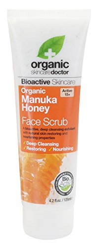 White tube with orange accents, featuring "DR ORGANIC Face Scrub Organic Manuka Honey" text, 125ml, highlighting deep cleansing and nourishing properties.