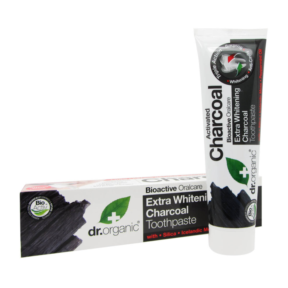 Black and white tube of Dr Organic Charcoal Whitening Toothpaste, featuring a green leaf logo, with a matching box displaying product details and ingredients.