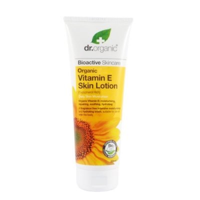 White tube of Dr Organic Vitamin E Body Lotion featuring a bright yellow label with a sunflower design, emphasizing organic ingredients and skin hydration benefits.