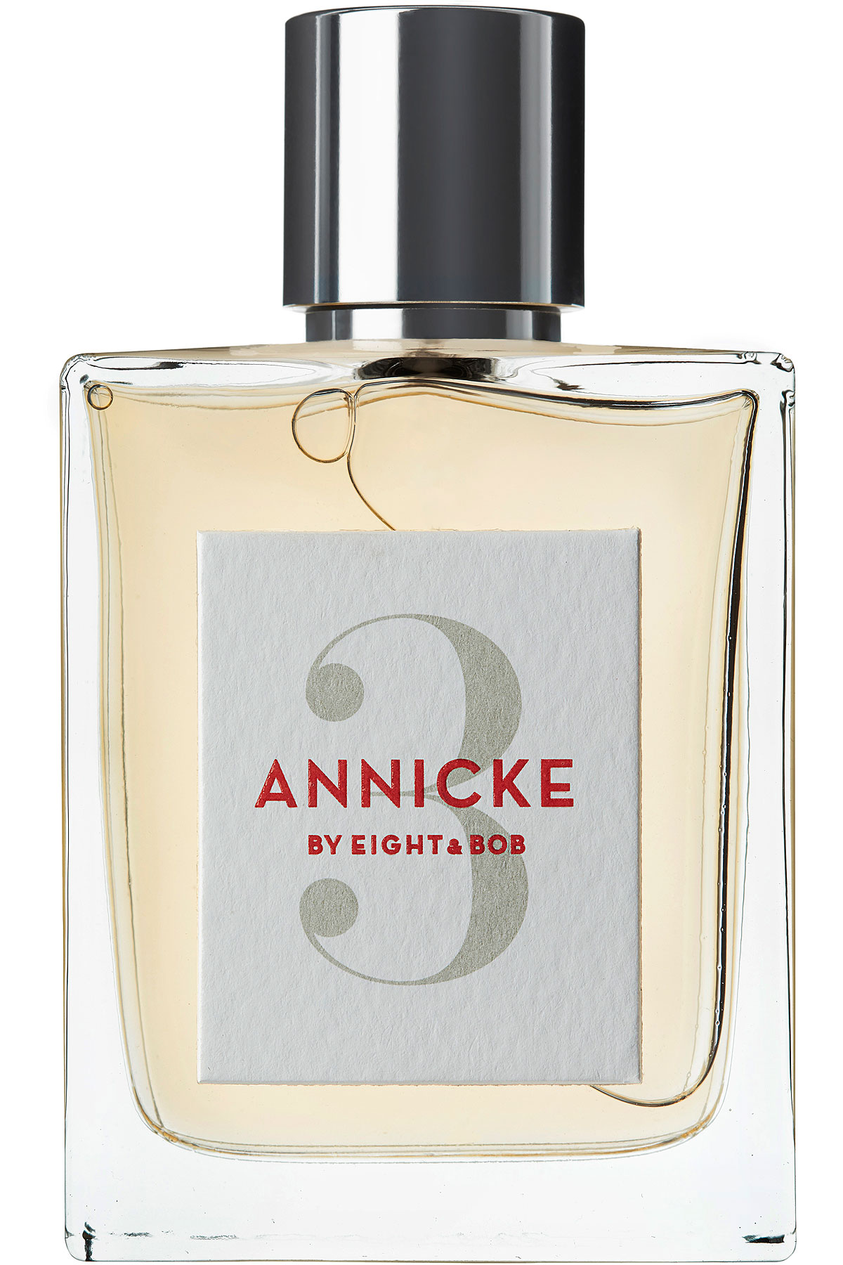 Clear glass bottle with a silver cap, featuring a white label with red and gray text that reads "ANNICKE 3 by Eight & Bob," containing a light yellow fragrance.