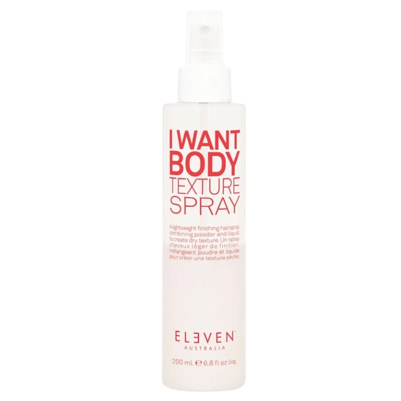Clear spray bottle with a white cap, labeled "I WANT BODY Texture Spray" in bold red letters, containing 200 mL of a lightweight finishing hair product by Eleven Australia.