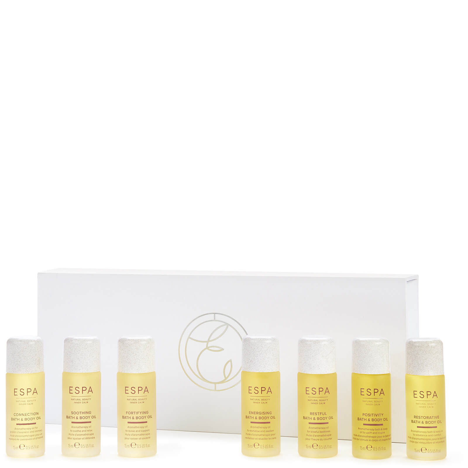 Eight small bottles of aromatherapy bath and body oils in clear glass, featuring a light yellow liquid, arranged in a white box with a gold logo.