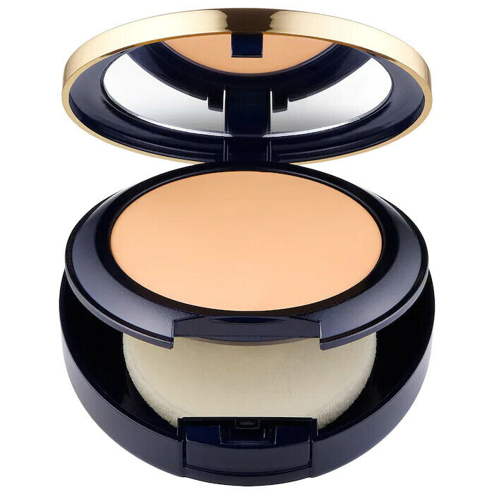 Compact powder with a smooth, outdoor beige shade, featuring a gold-trimmed navy blue case and a soft applicator sponge inside.