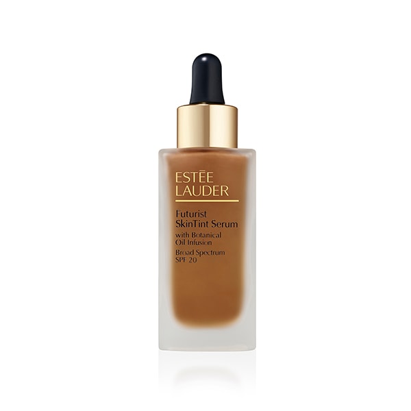 Brown serum foundation in a clear glass bottle with a dropper top, featuring a gold cap and label with "Estée Lauder" and "Futurist SkinTint Serum SPF 20" text.