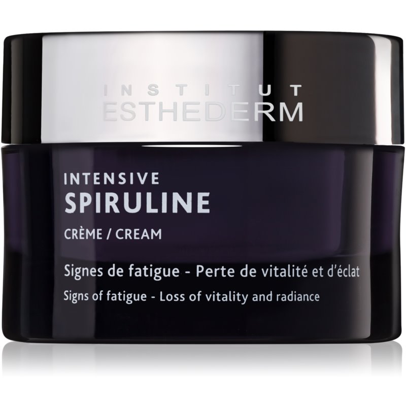 Dark purple jar with a glossy black lid, labeled "Institut Esthederm Intensive Spiruline Crème" in white text, highlighting revitalizing properties for skin vitality and radiance.